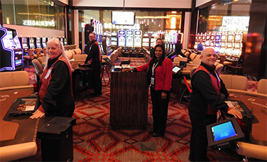pit manager and team on the casino floor next to their table games